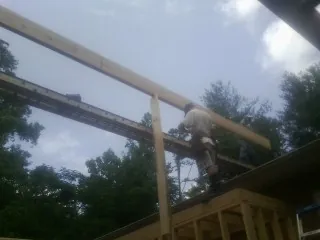 Carpenter setting a ridge beam over a new addition frame — Ice Dam Removal by Roofing Brothers in Chappaqua