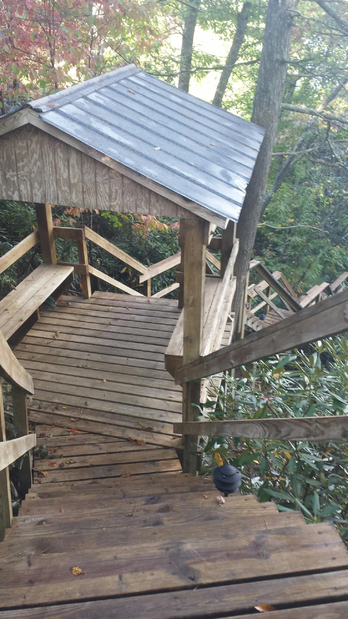 Metal roofed shelter over wooden steps on a wooded walkway — Skylight Repair & Installation work by our crew in Chappaqua