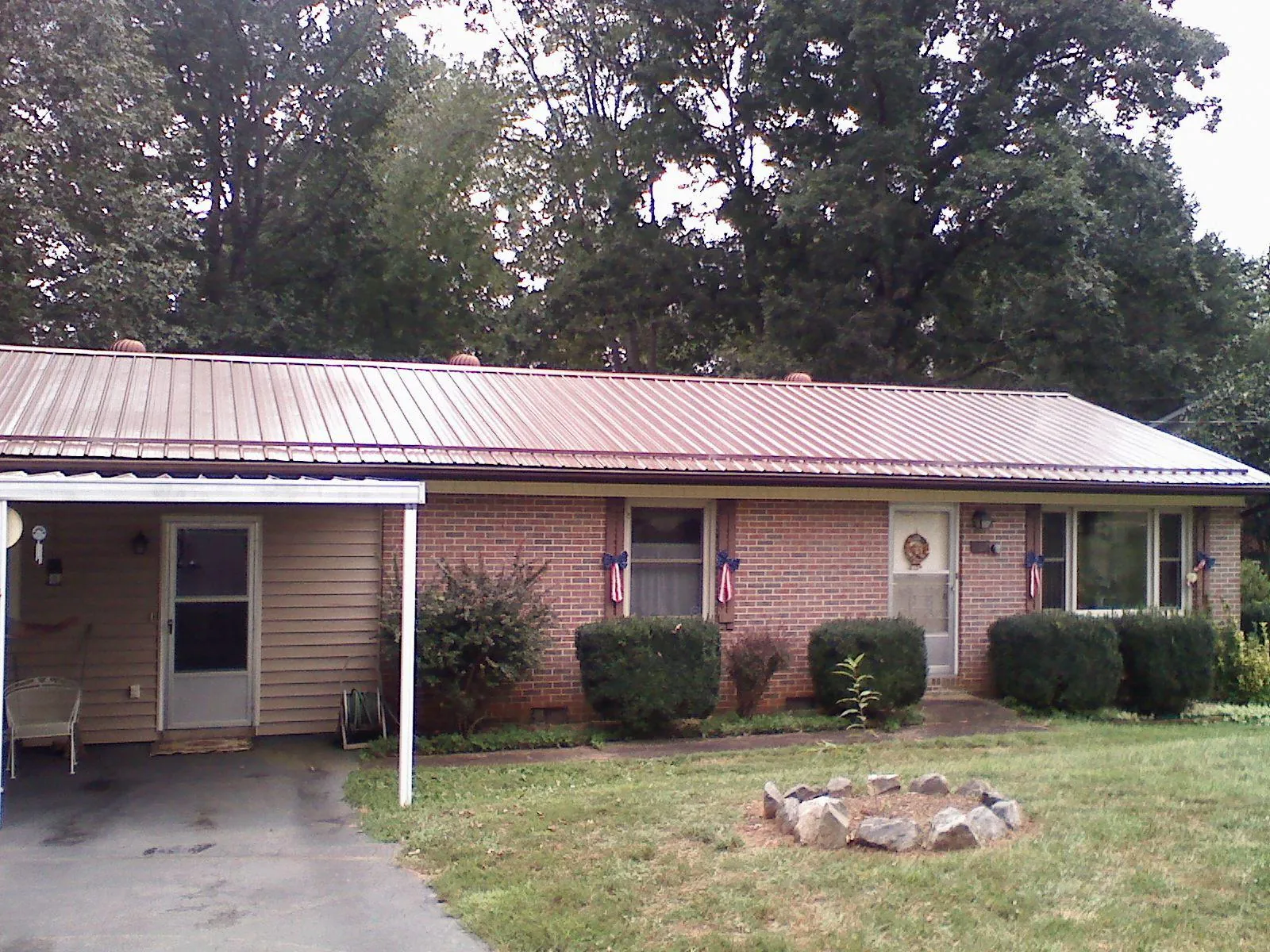 Bronze metal roof and carport on a brick ranch home — Roof Repair work by our crew in Chappaqua
